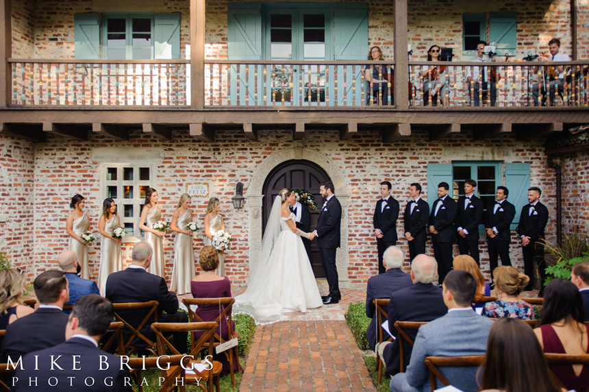 bride and groom surrounded by their guests at an outdoor weddings